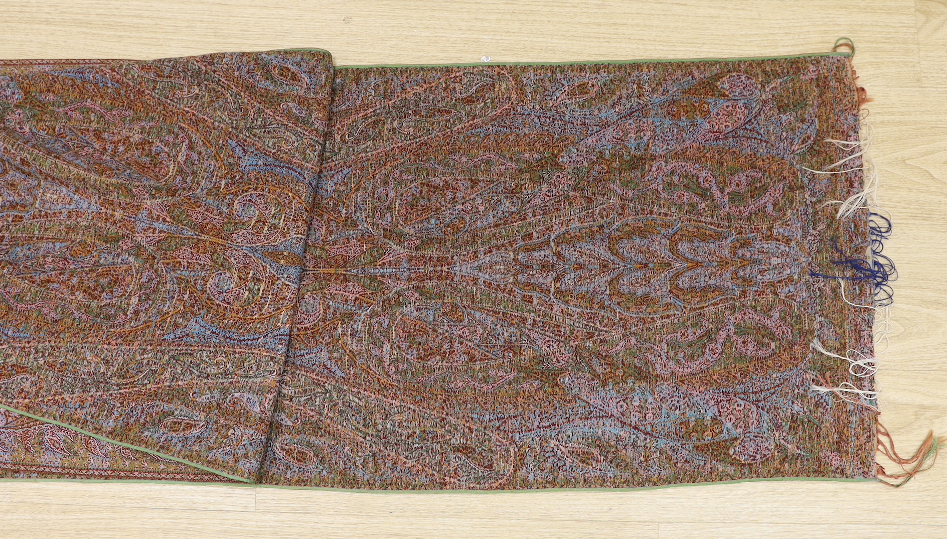 An Indian cream ground paisley stole with un-woven cream centre and heavily woven multi-coloured borders and ends, both fringed, 273 x 52cm
